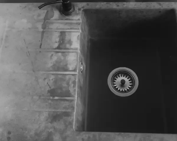 Czarny zlew granitowy z ociekaczem i baterią.